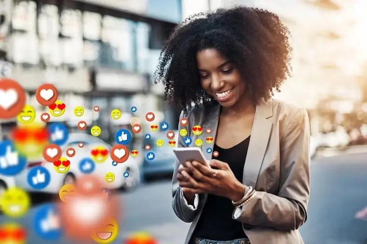 A lady on her mobile phone smiling while interacting with her social media platforms